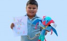 boy holding drawing that was made into stuffed animal