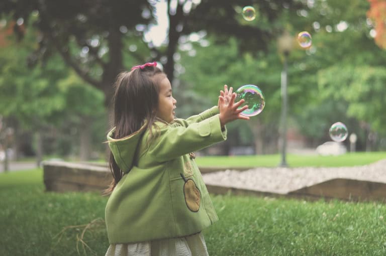 child playing with bubbles